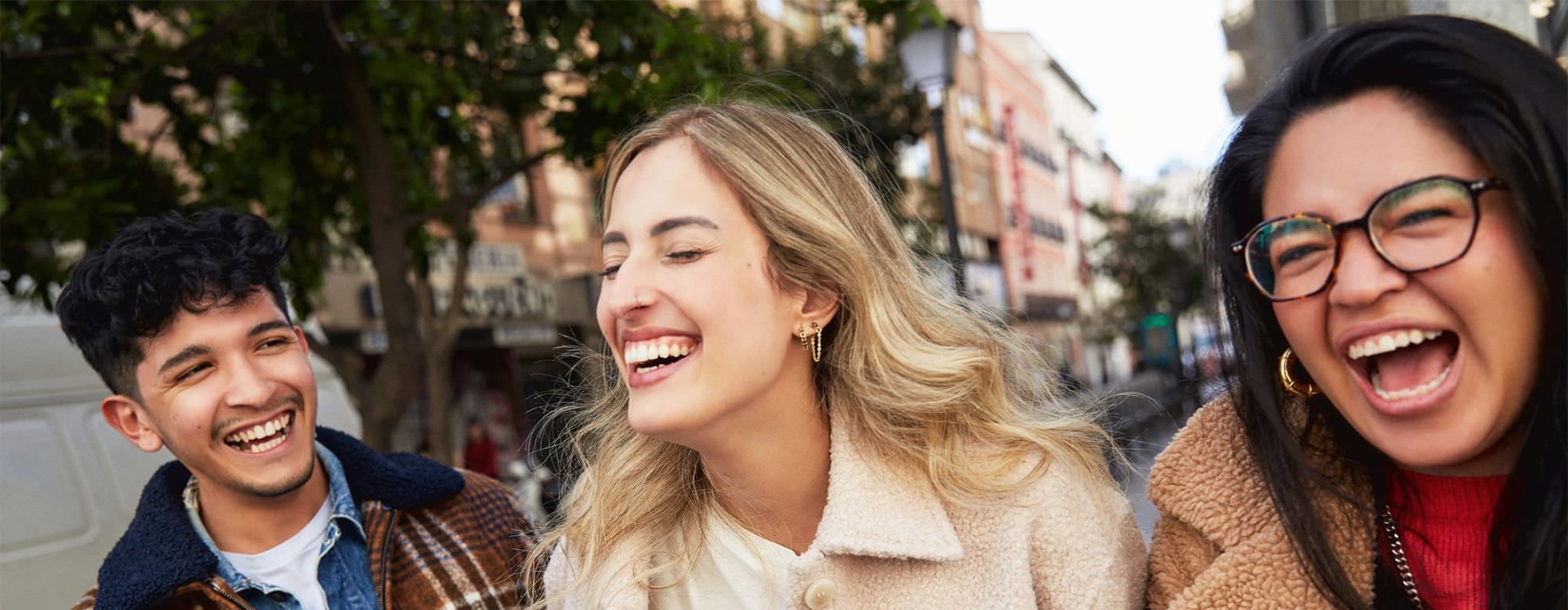 people laughing while walking in a city