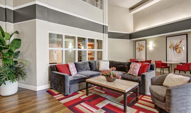 a clubroom with a couch, tables and chairs