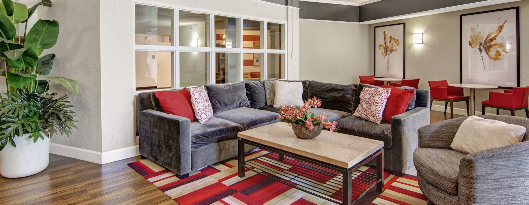 a clubroom with a couch, tables and chairs